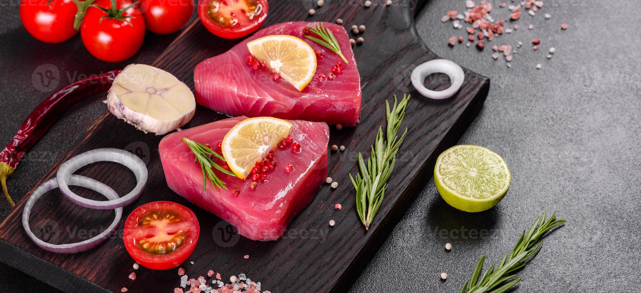 Filetes de atún fresco con especias y hierbas sobre un fondo negro foto