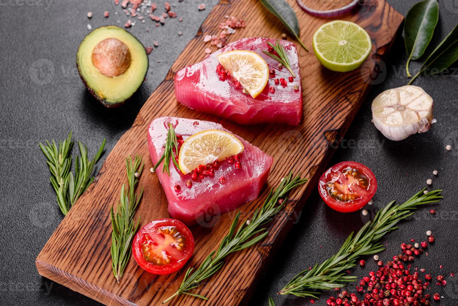 Filetes de atún fresco con especias y hierbas sobre un fondo negro foto