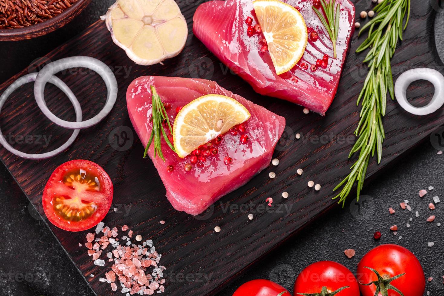 Filetes de atún fresco con especias y hierbas sobre un fondo negro foto