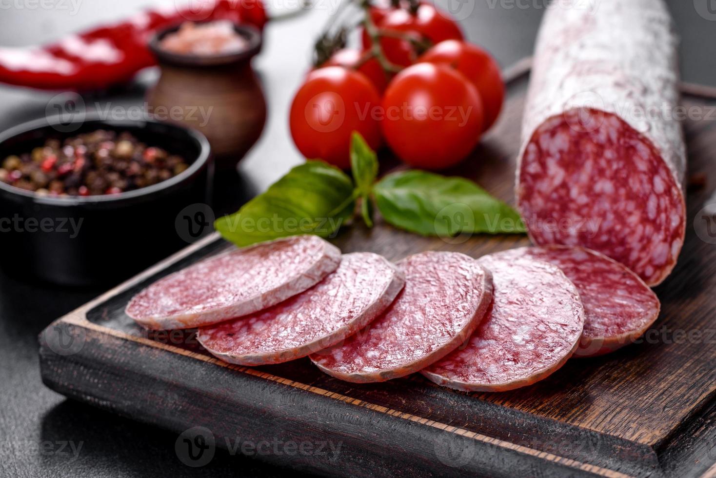 Español salami salchicha seca sobre un fondo de hormigón oscuro foto