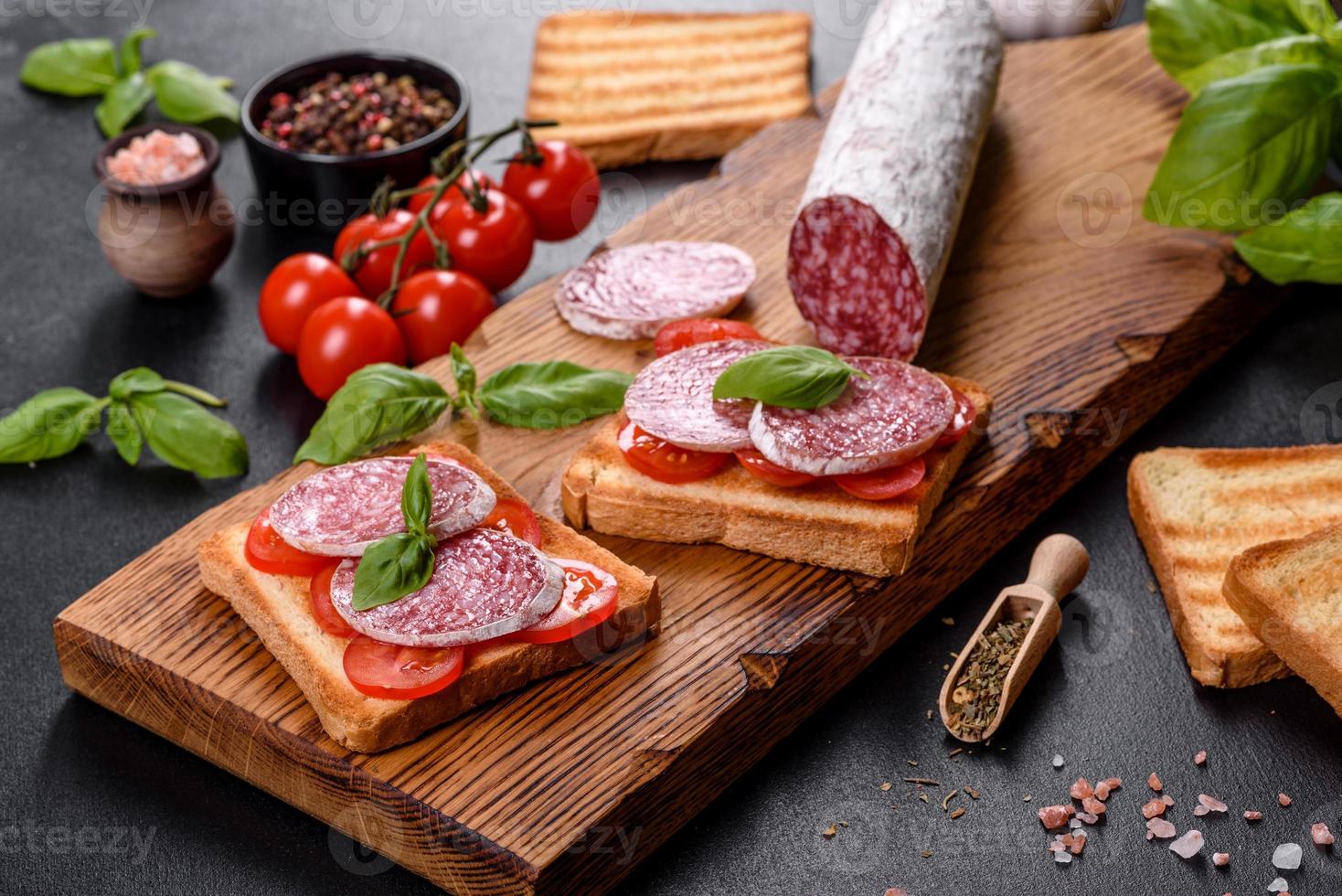 Spanish dried sausage salami on a dark concrete background photo