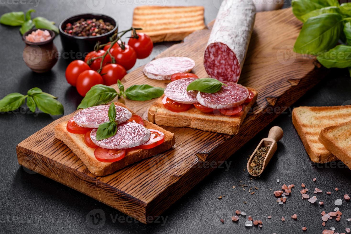 Español salami salchicha seca sobre un fondo de hormigón oscuro foto