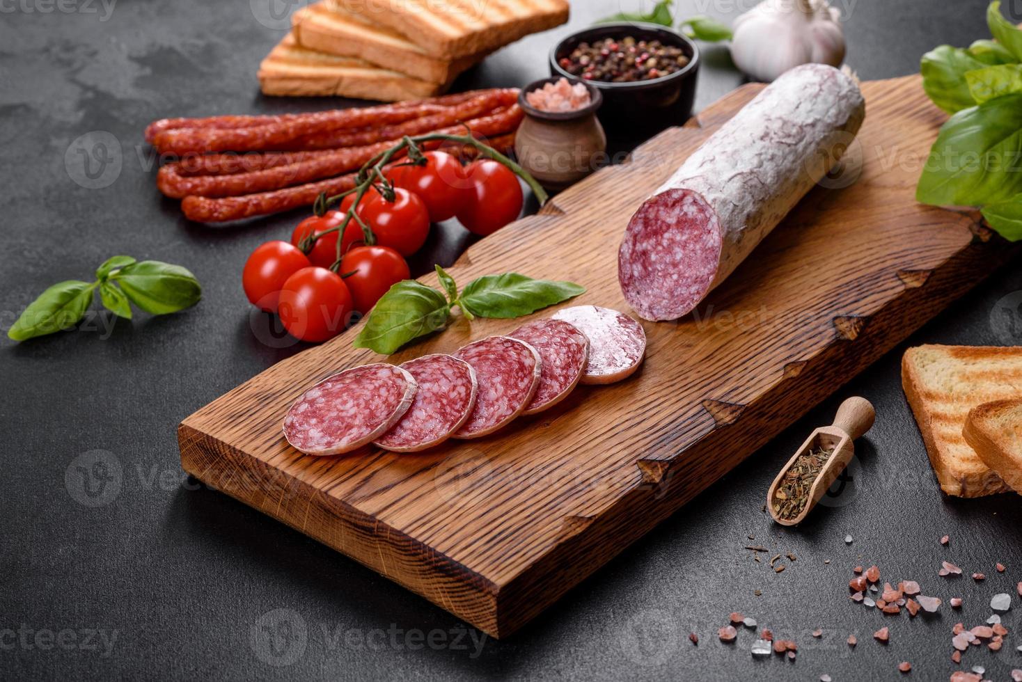 Spanish dried sausage salami on a dark concrete background photo