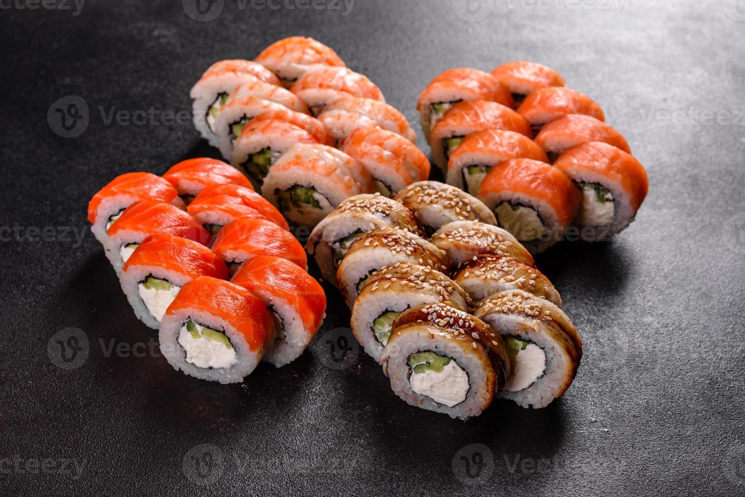 Rollos de sushi hermosos y deliciosos frescos sobre un fondo oscuro foto