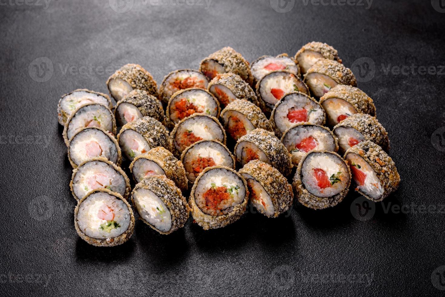 Fresh delicious beautiful sushi rolls on a dark background photo