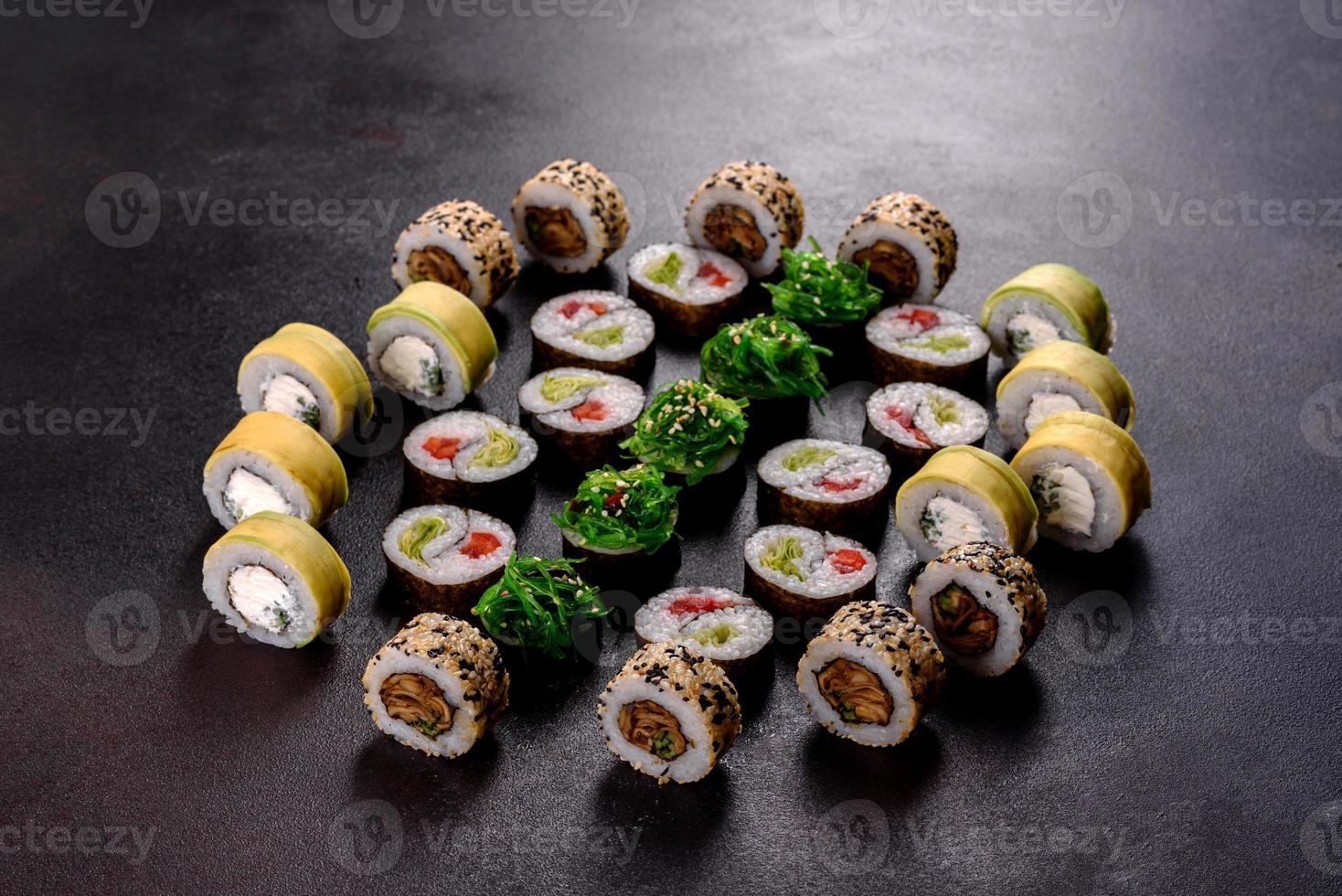 Fresh delicious beautiful sushi rolls on a dark background photo