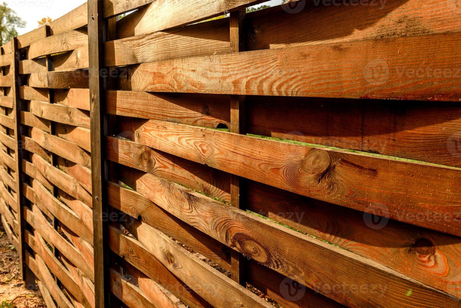 una vieja valla de tablones de madera alrededor de una parcela de tierra foto