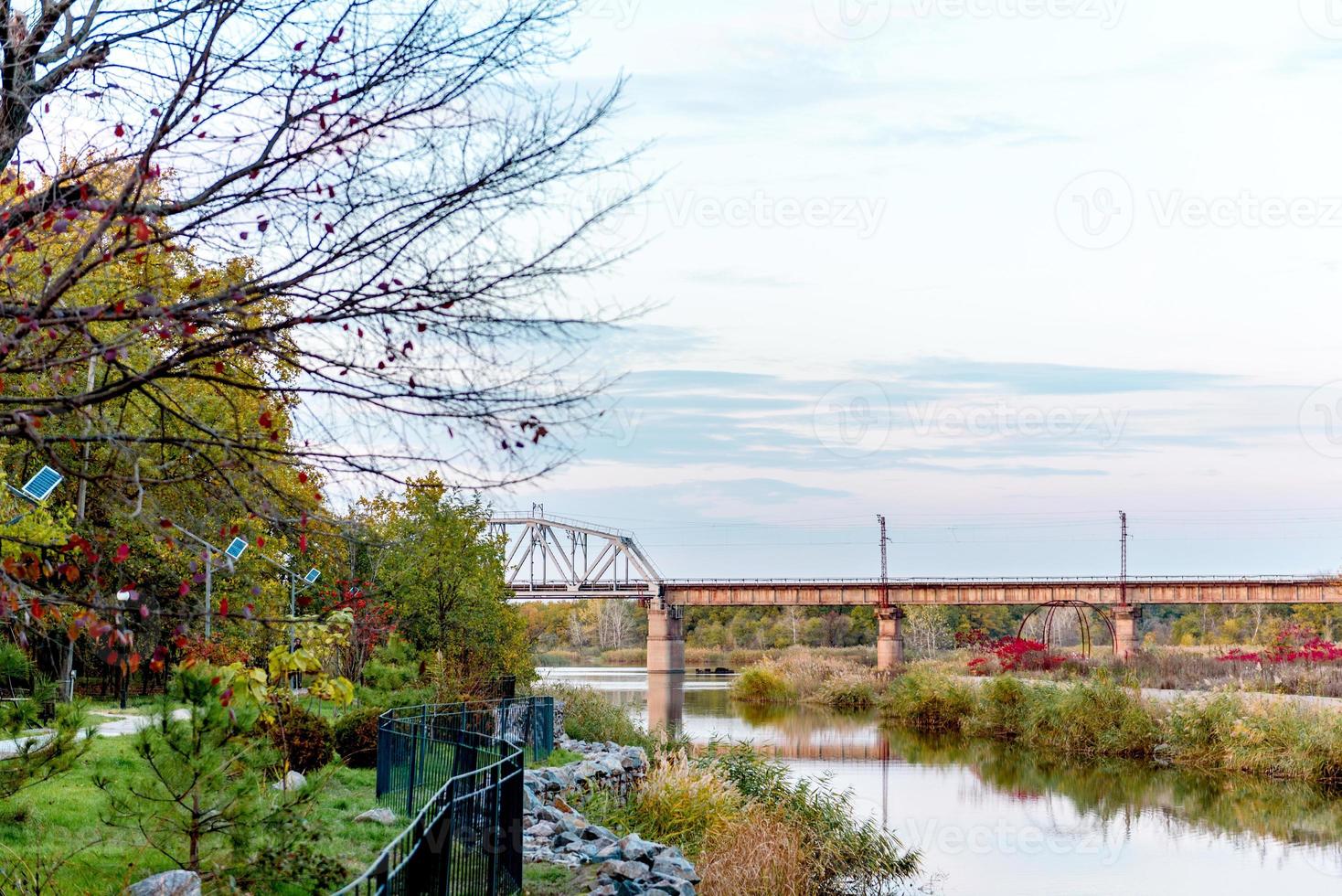 A metal railway bridge connecting two river banks photo