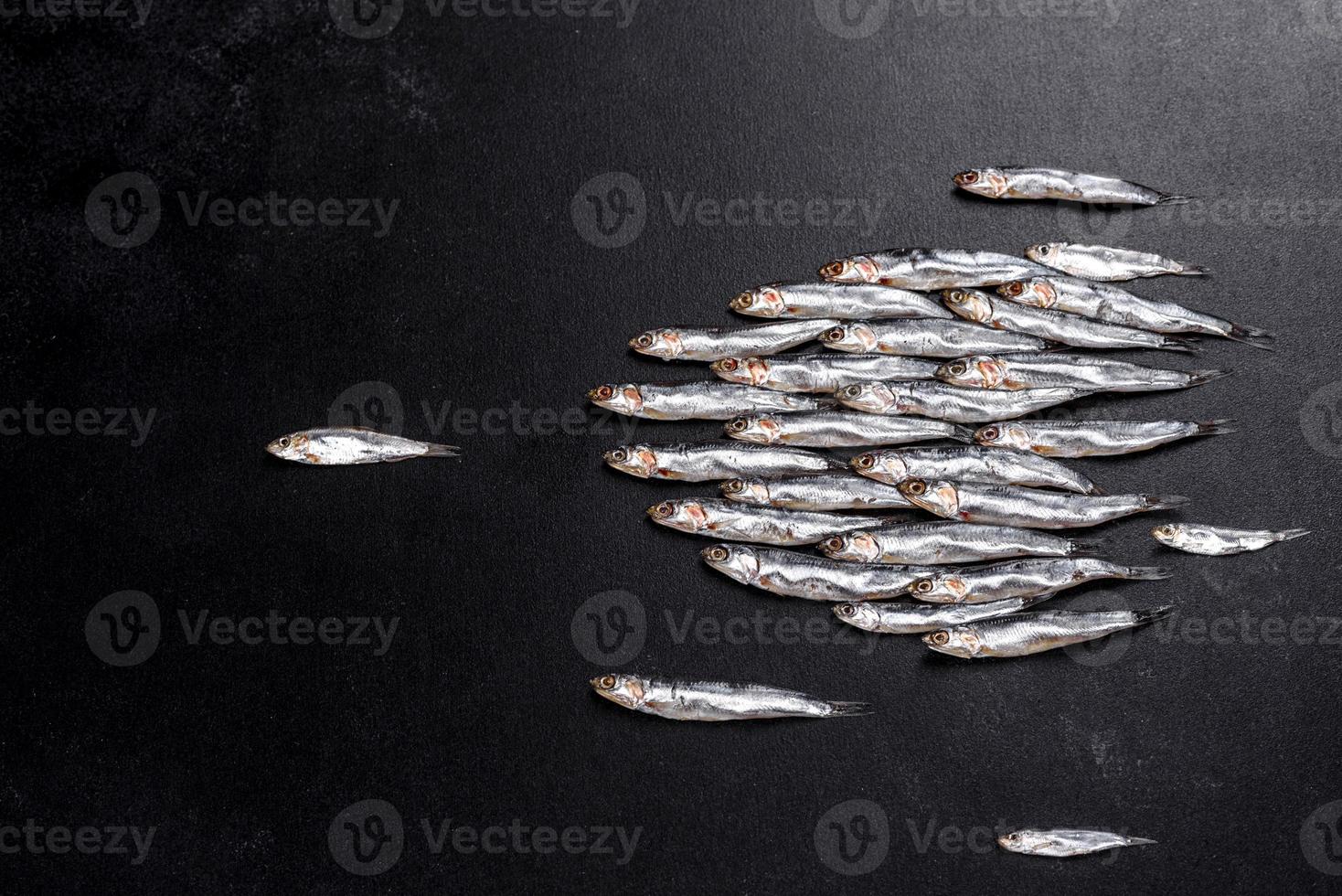 Several fish salted anchovies on a dark concrete table photo