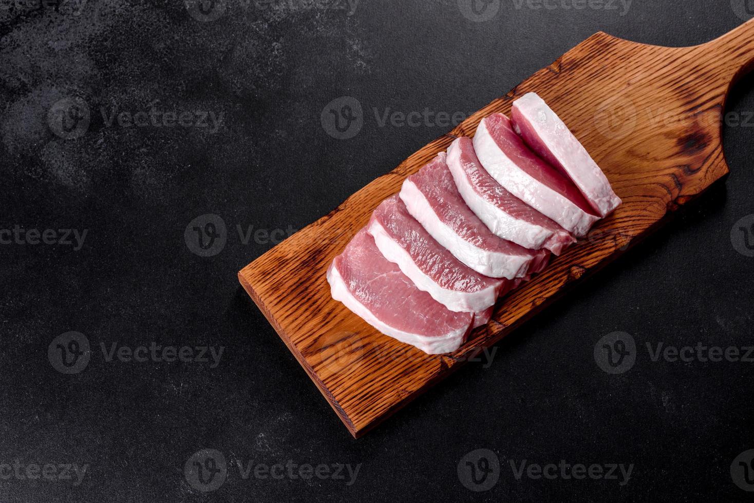 A fresh raw piece of pork escalop cut into several parts photo