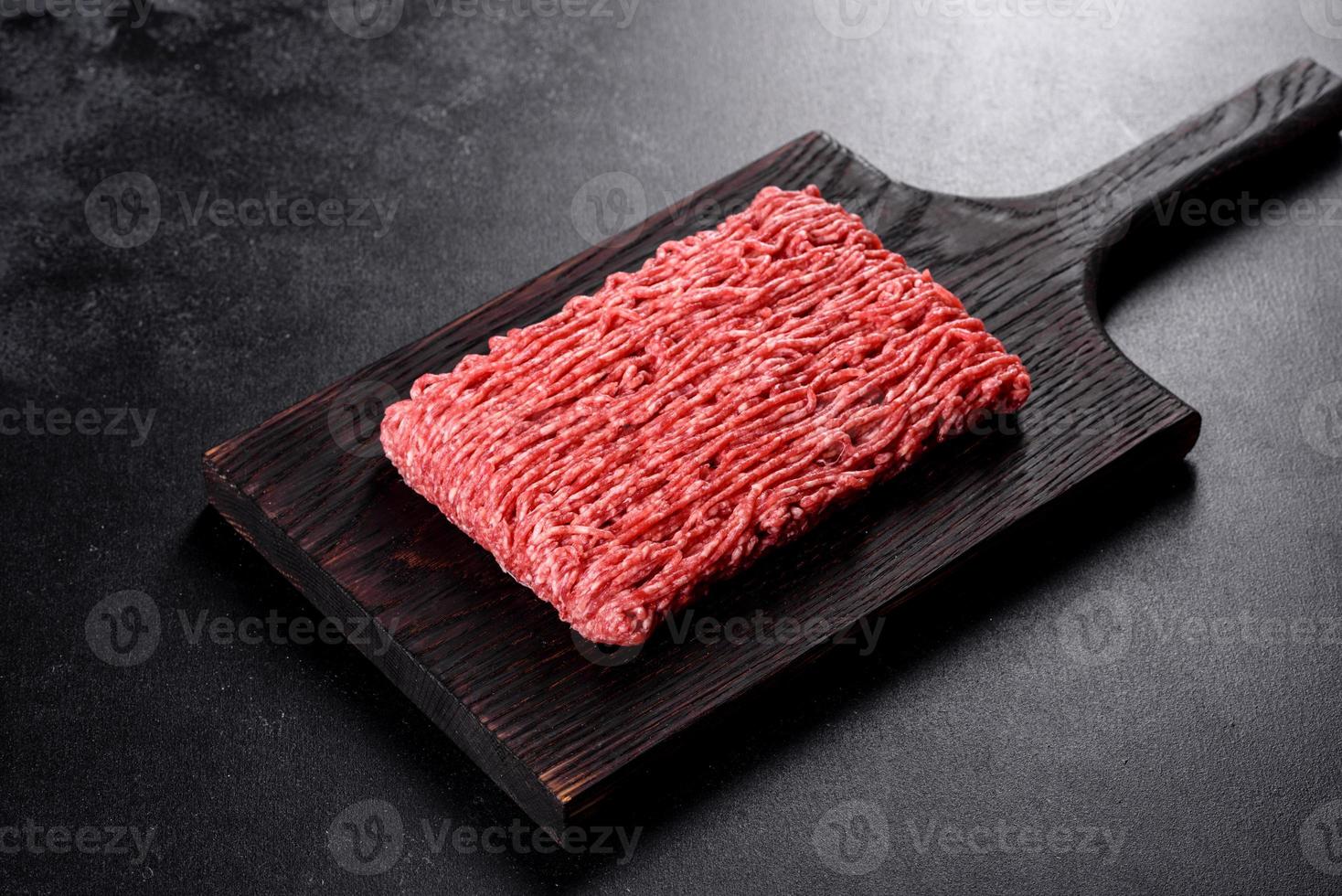 Carne picada fresca cruda sobre un fondo oscuro foto