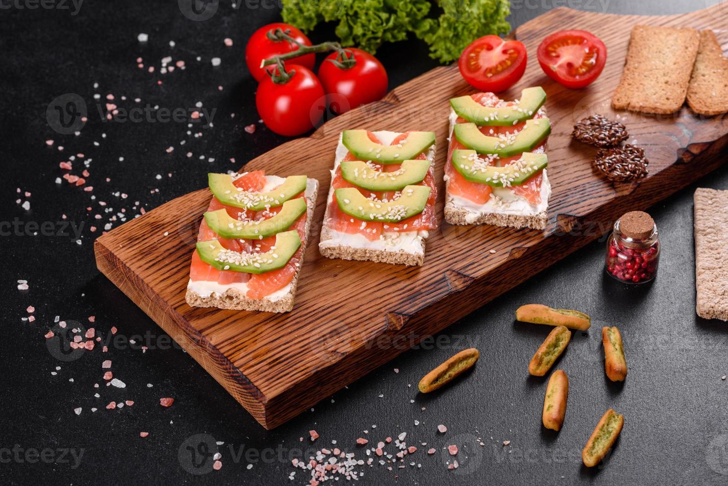 Delicious fresh sandwich with red fish, butter, bread and avocado photo