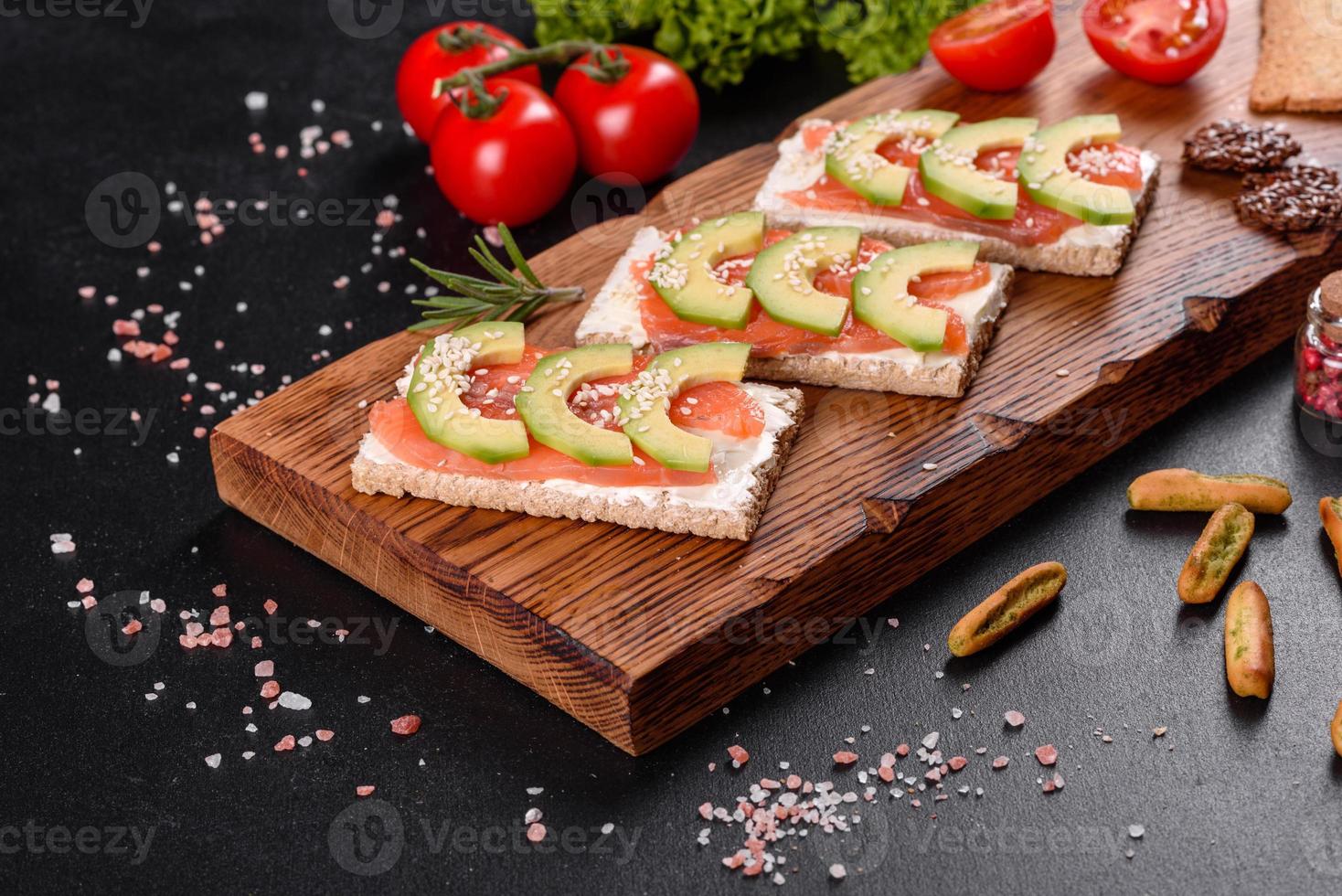 Delicious fresh sandwich with red fish, butter, bread and avocado photo
