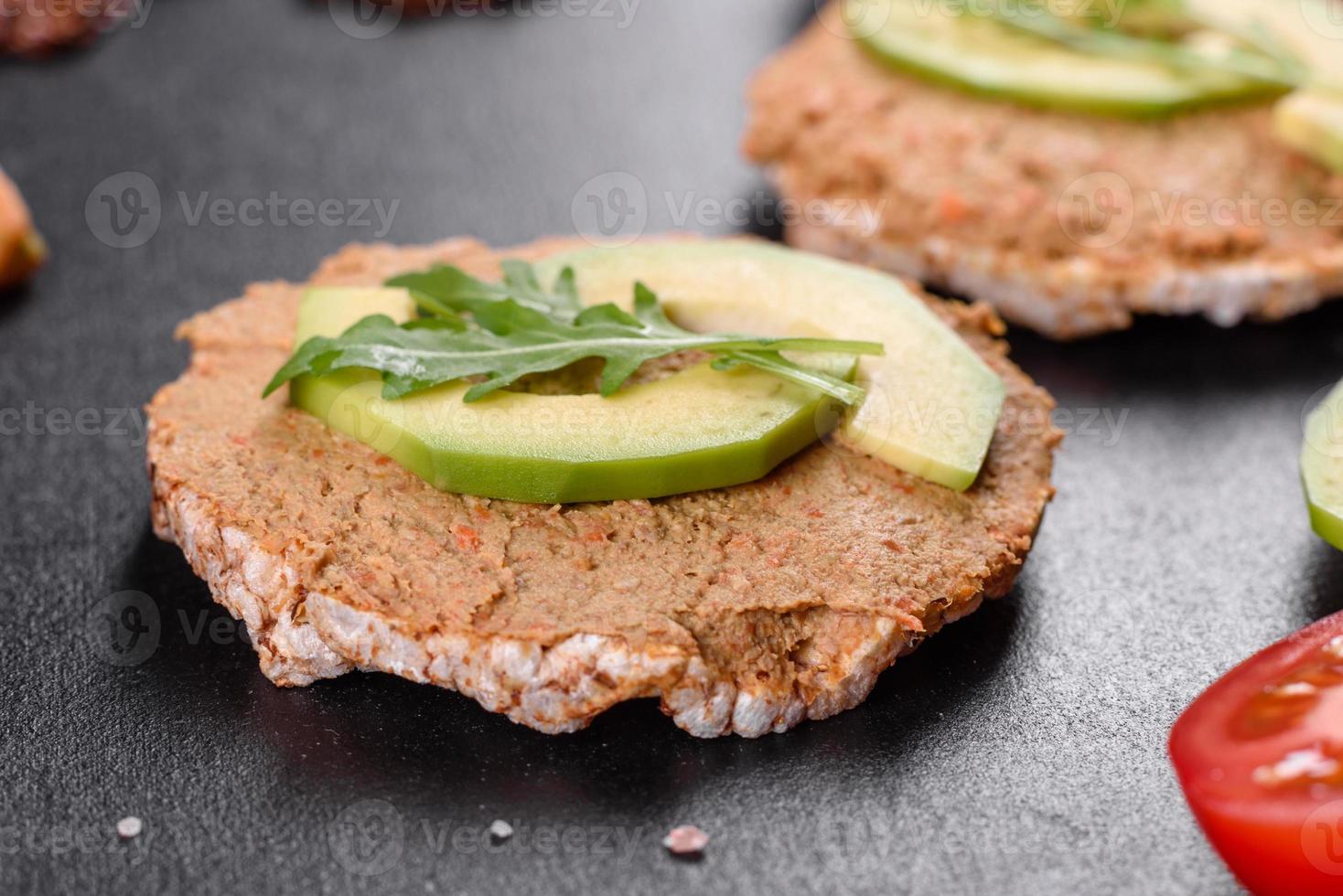 Tasty fresh sandwich with liver paste, avocado pieces and a arugula photo