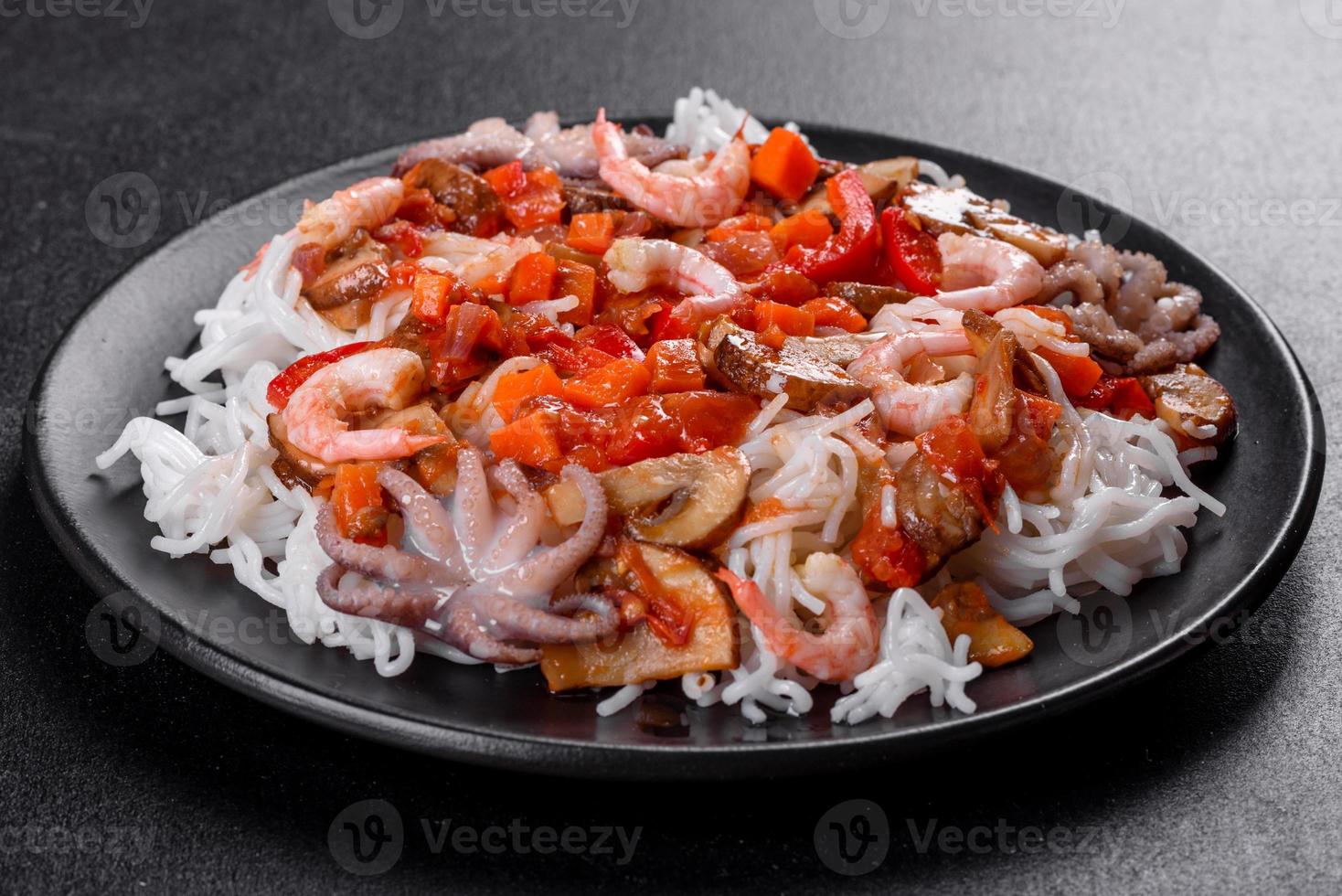 sabrosos fideos de arroz con tomate, pimiento rojo, champiñones y marisco foto