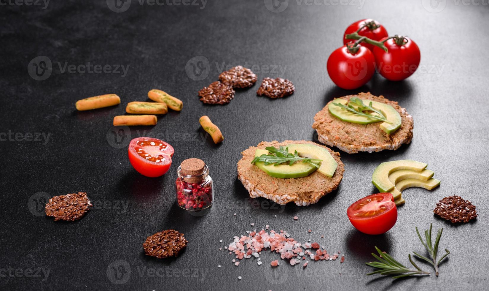 Tasty fresh sandwich with liver paste, avocado pieces and a arugula photo