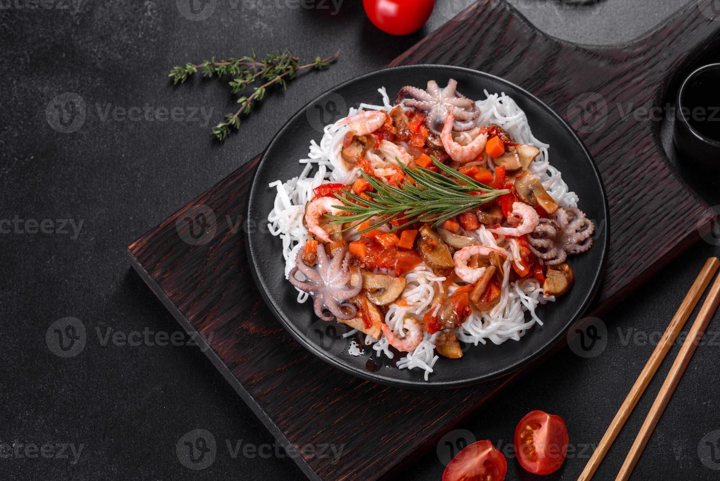 Tasty rice noodles with tomato, red pepper, mushrooms and seafood photo