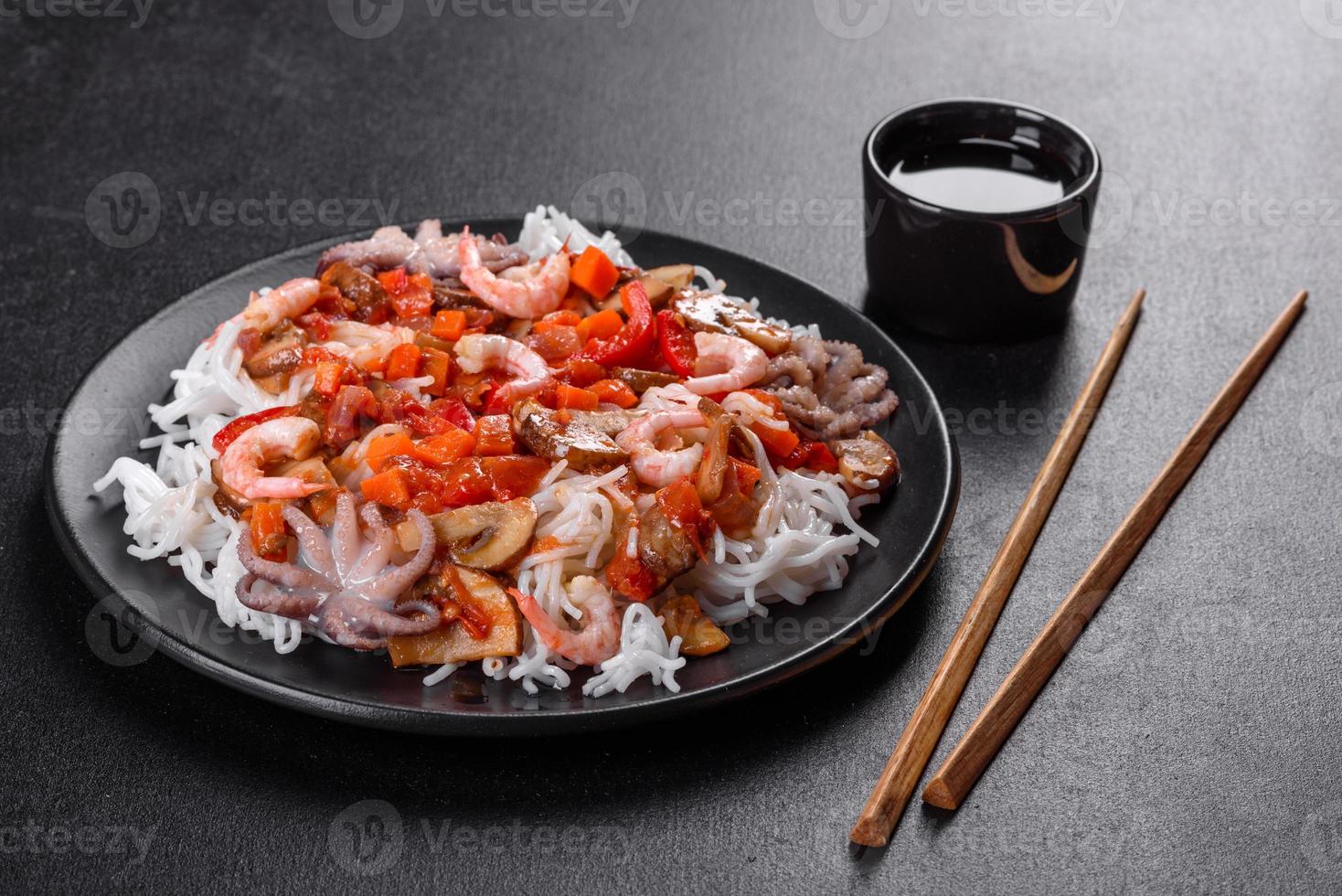 sabrosos fideos de arroz con tomate, pimiento rojo, champiñones y marisco foto