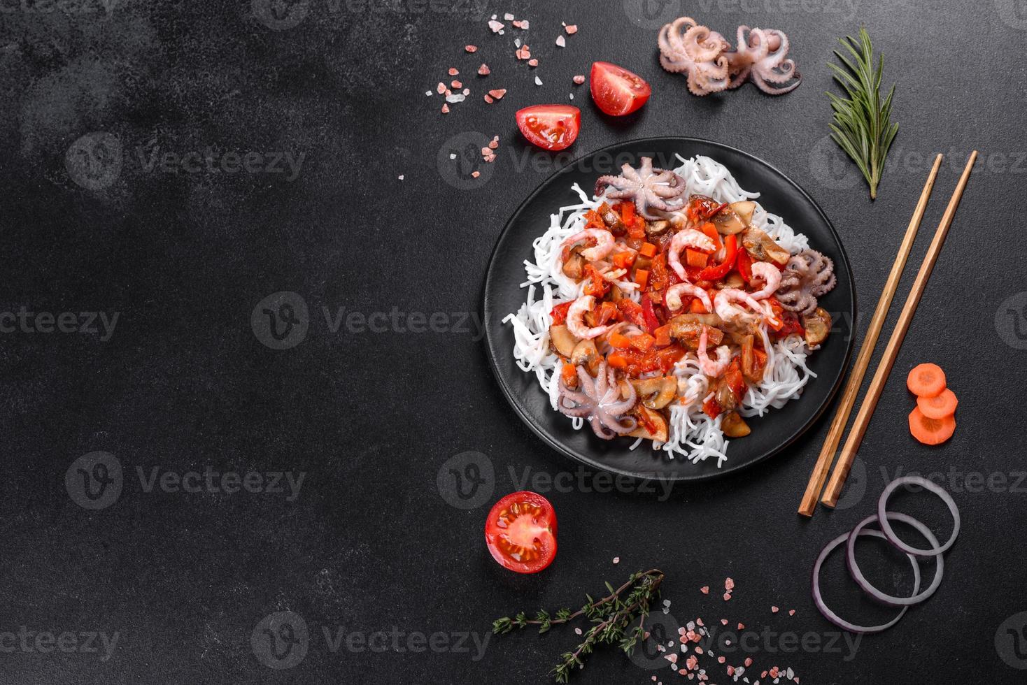 Tasty rice noodles with tomato, red pepper, mushrooms and seafood photo