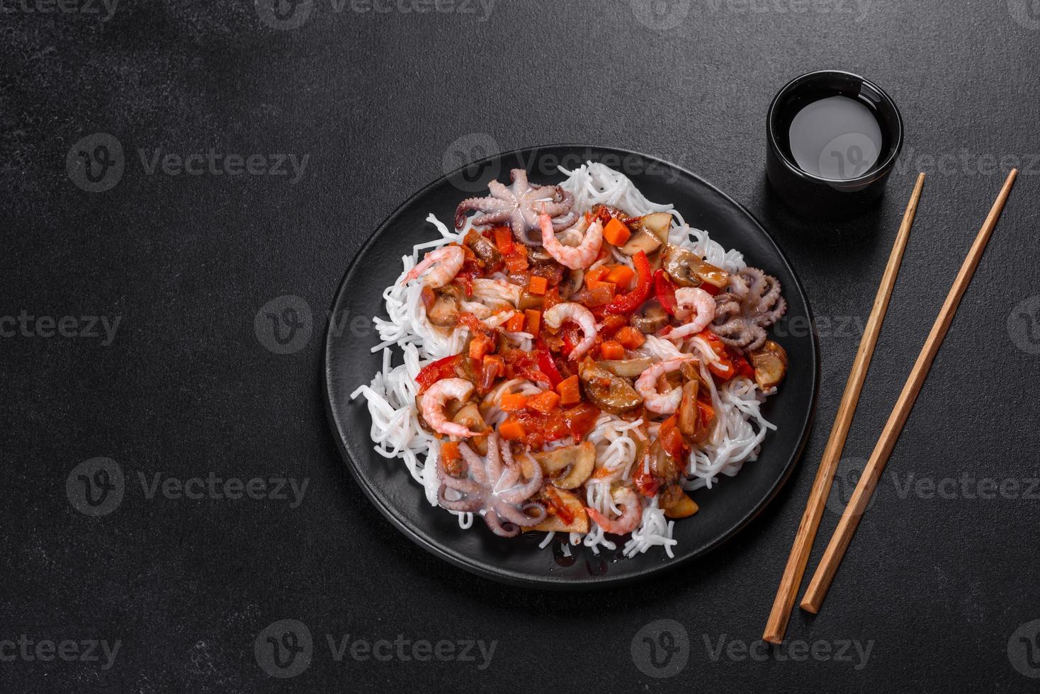 Tasty rice noodles with tomato, red pepper, mushrooms and seafood photo