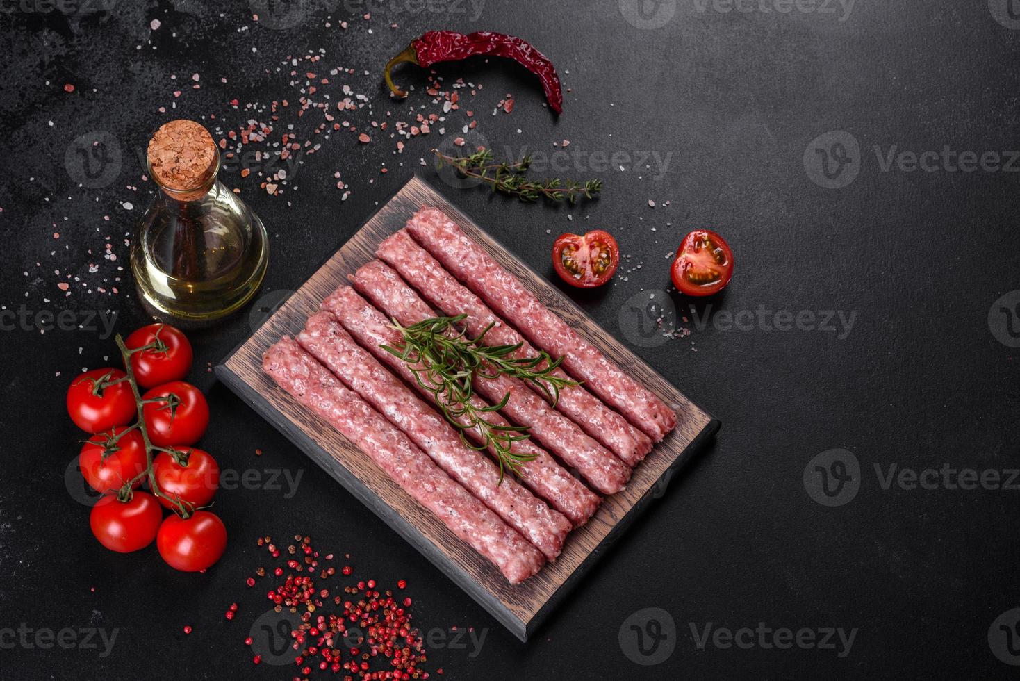 Fresh raw pork sausages with spices on a wooden cutting board photo