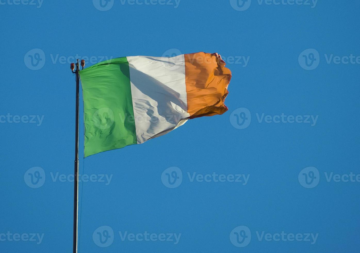 Bandera irlandesa de Irlanda sobre el cielo azul foto