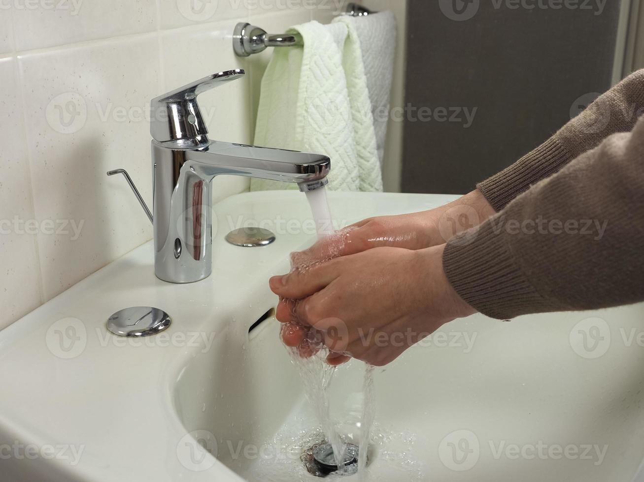 Unrecognisable man washing hands photo