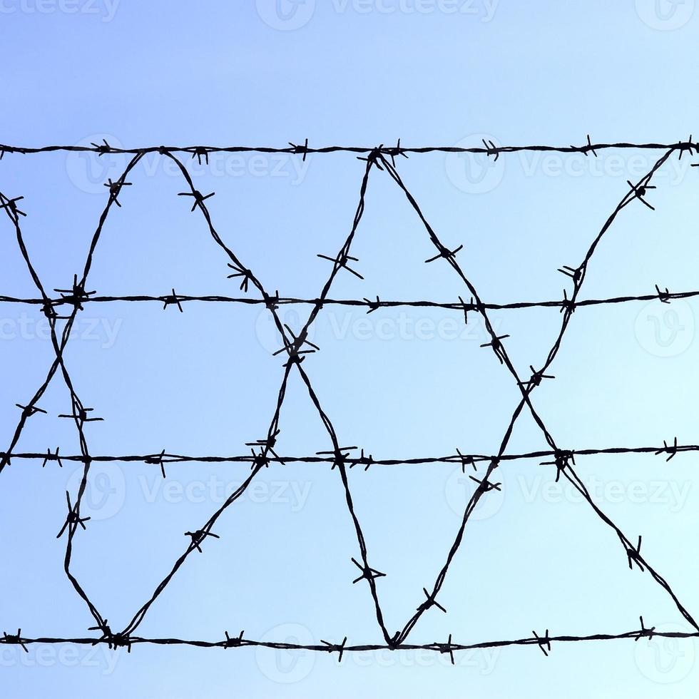 Barbed wire over blue sky photo