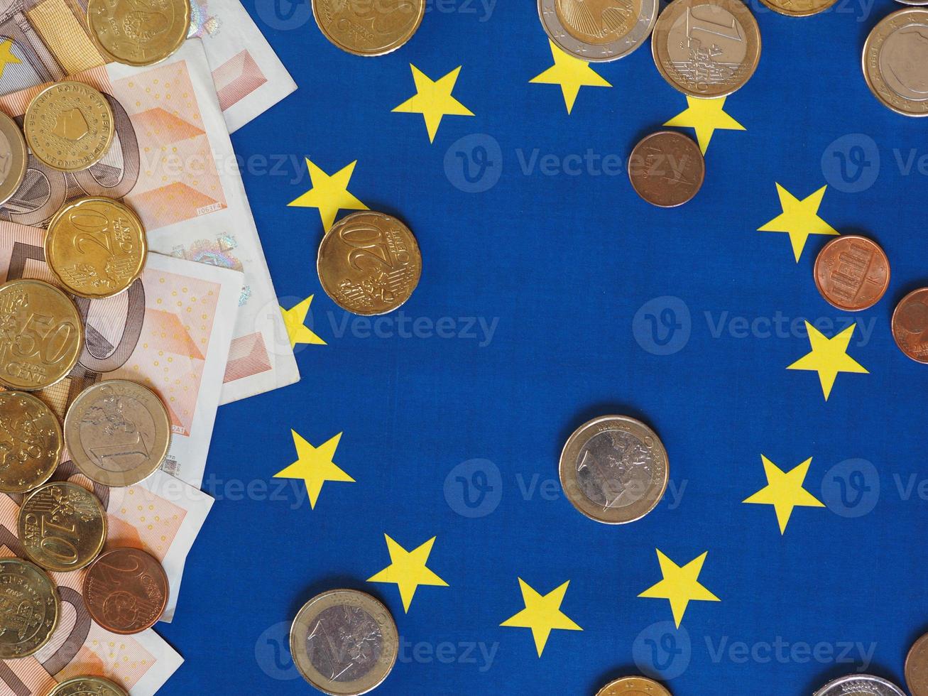 Euro notes and coins, European Union, over flag photo