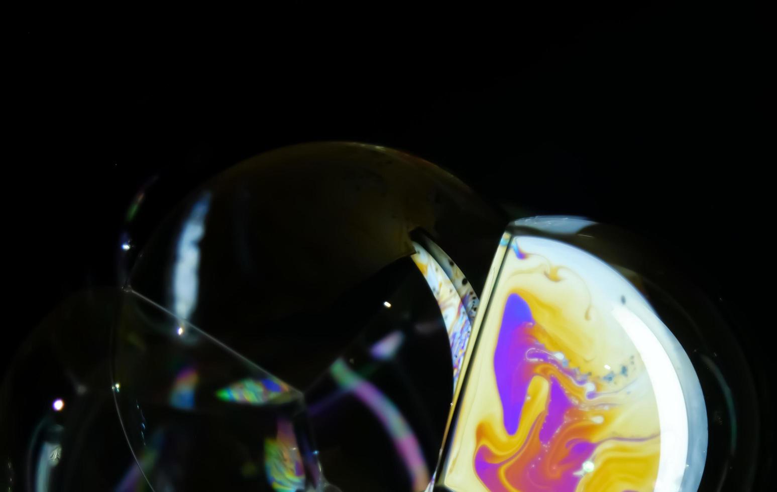 Soap bubble close up isolated on black background photo