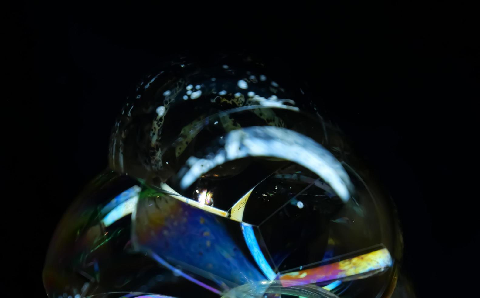 Soap bubble close up isolated on black background photo