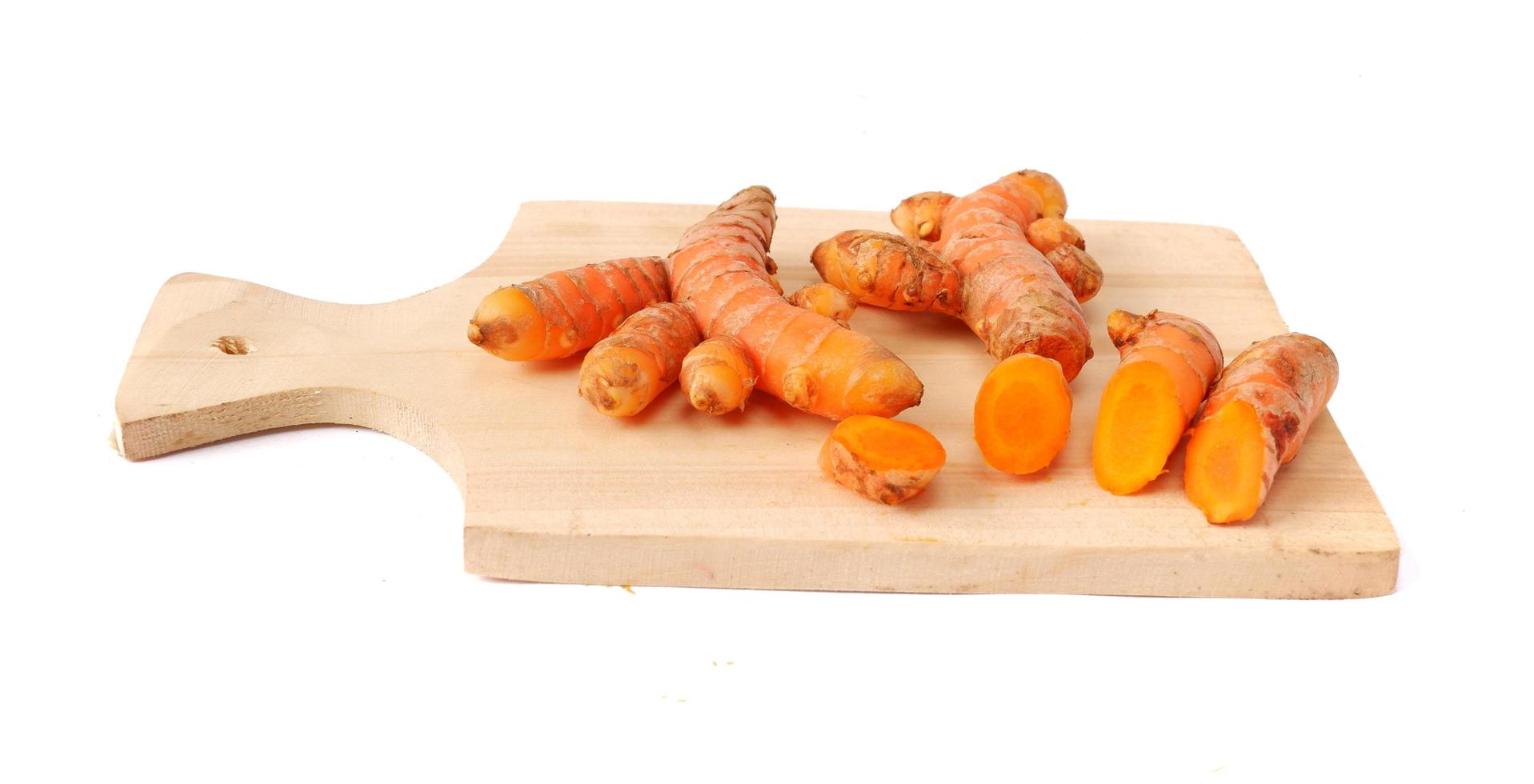 Turmeric on a wooden cutting board isolated on a white background photo