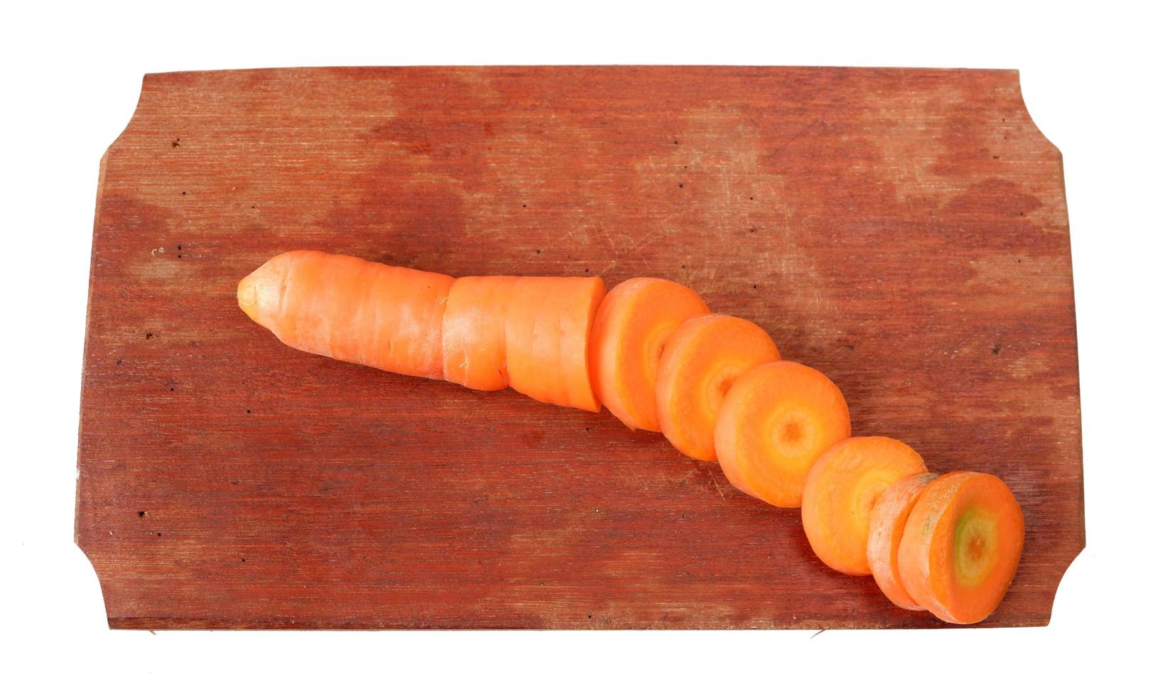 Carrots on a wooden cutting board isolated on a white background photo