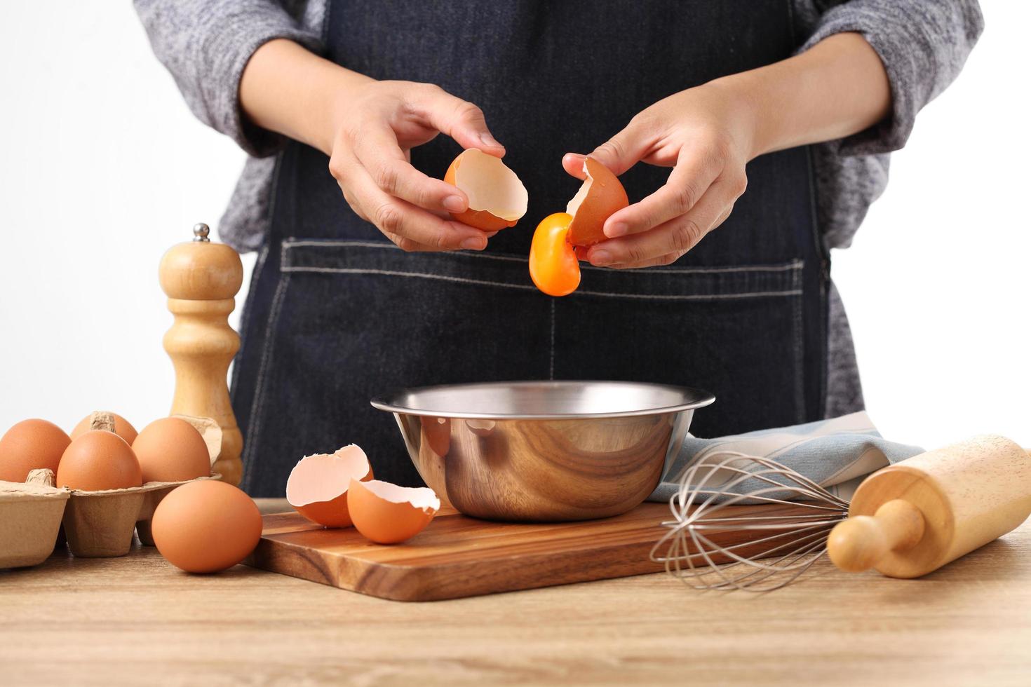 Woman hands to separate egg white and yolks with egg shells photo