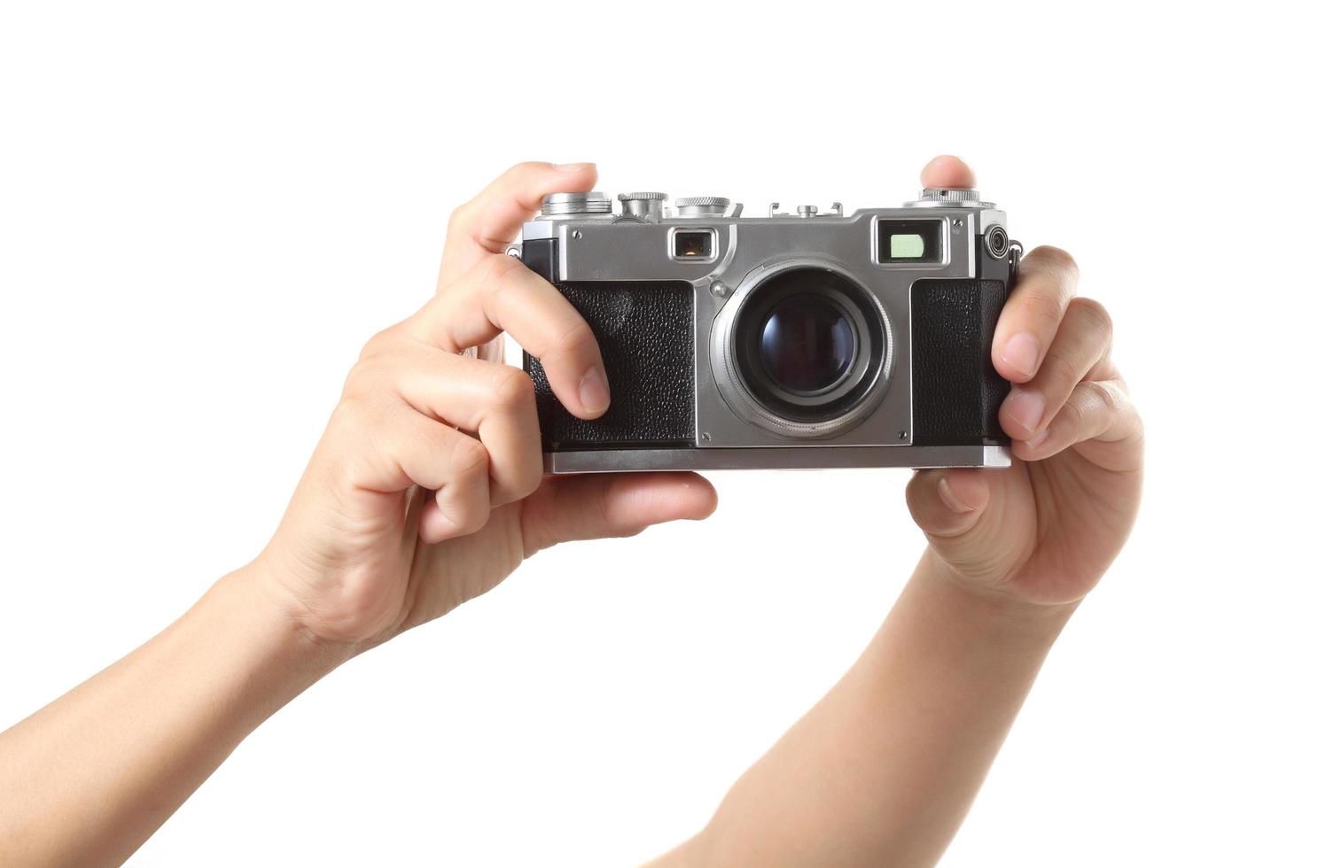 Hand holding vintage camera on white background photo