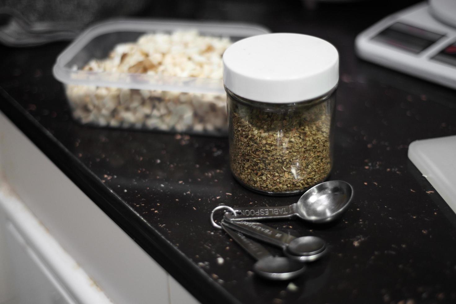 Bottle of oregano and tablespoon photo