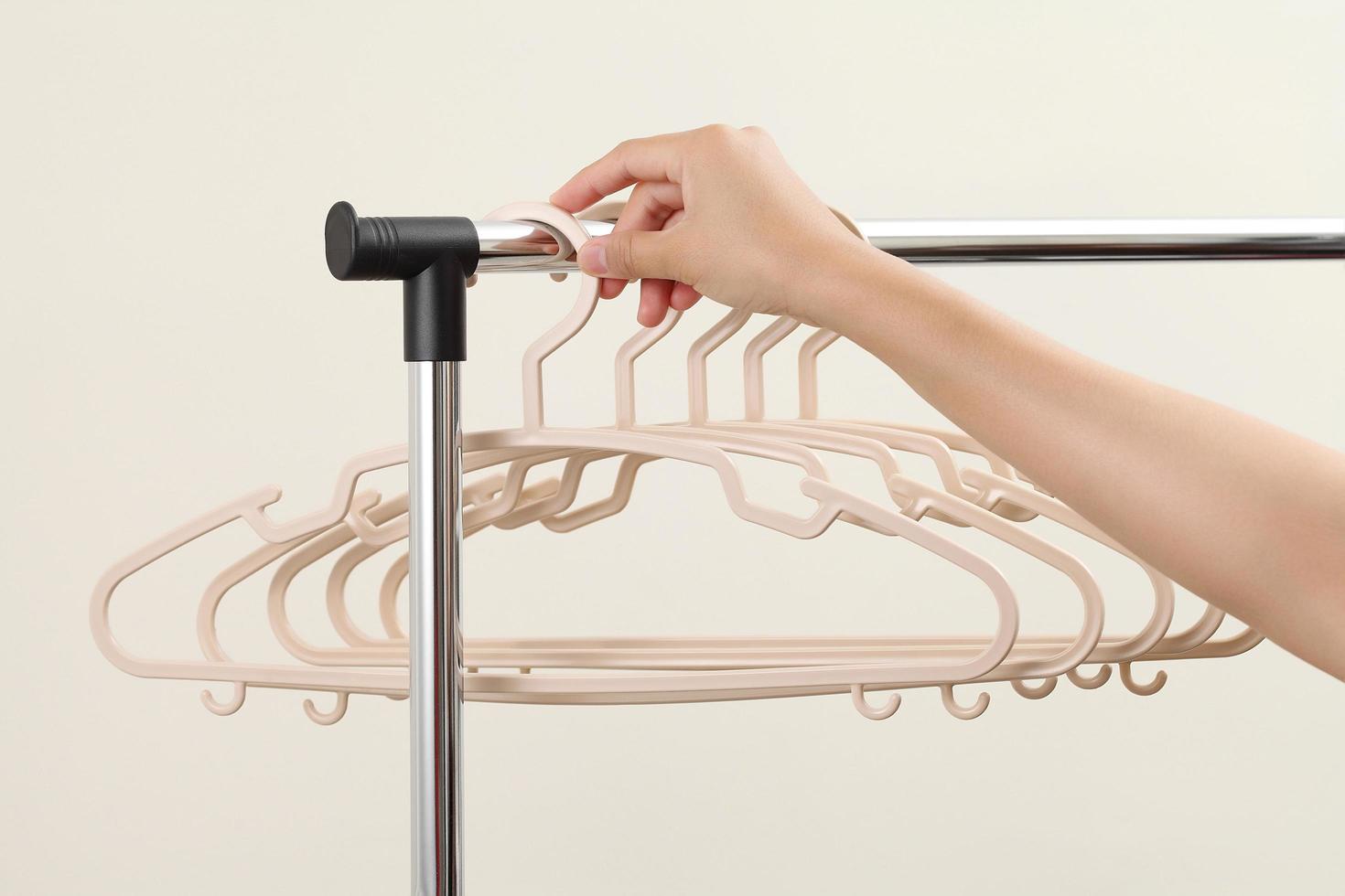 Women hand holding plastic hangers on rack photo