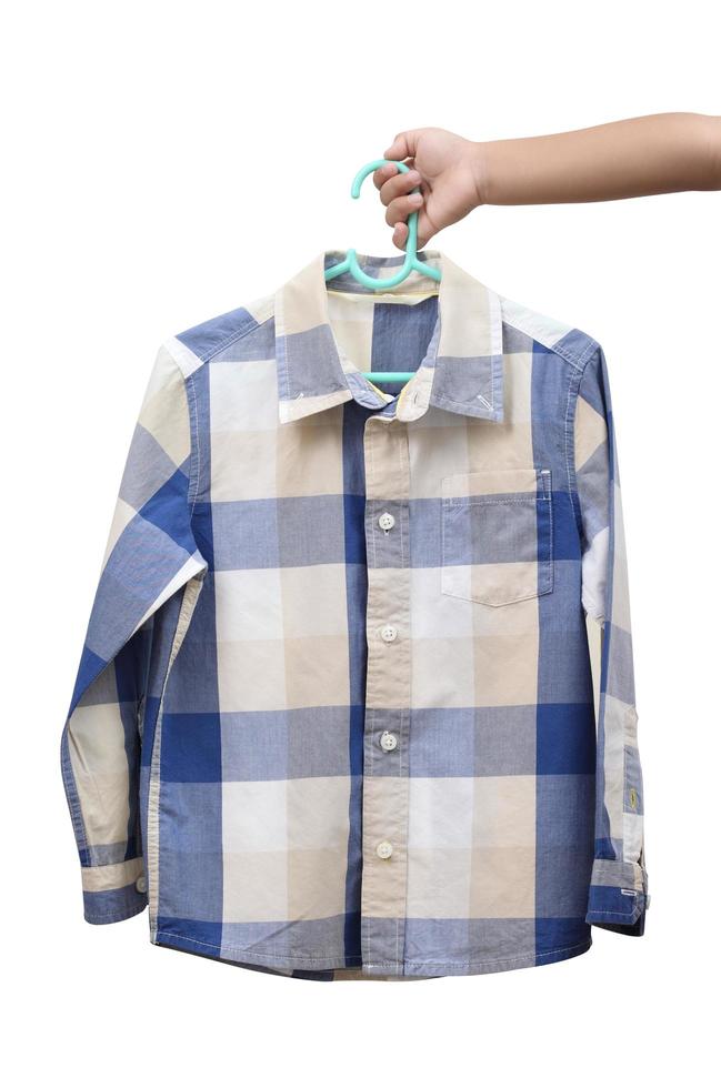 Children hand holding checkered boy shirt on white background photo