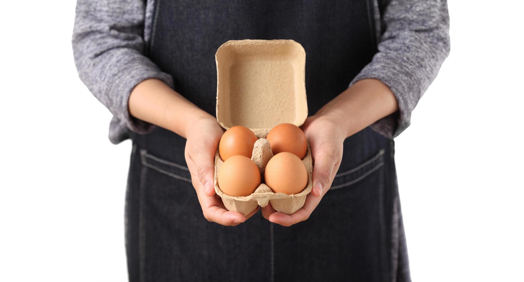 Woman holding fresh chicken eggs in cardboard box photo