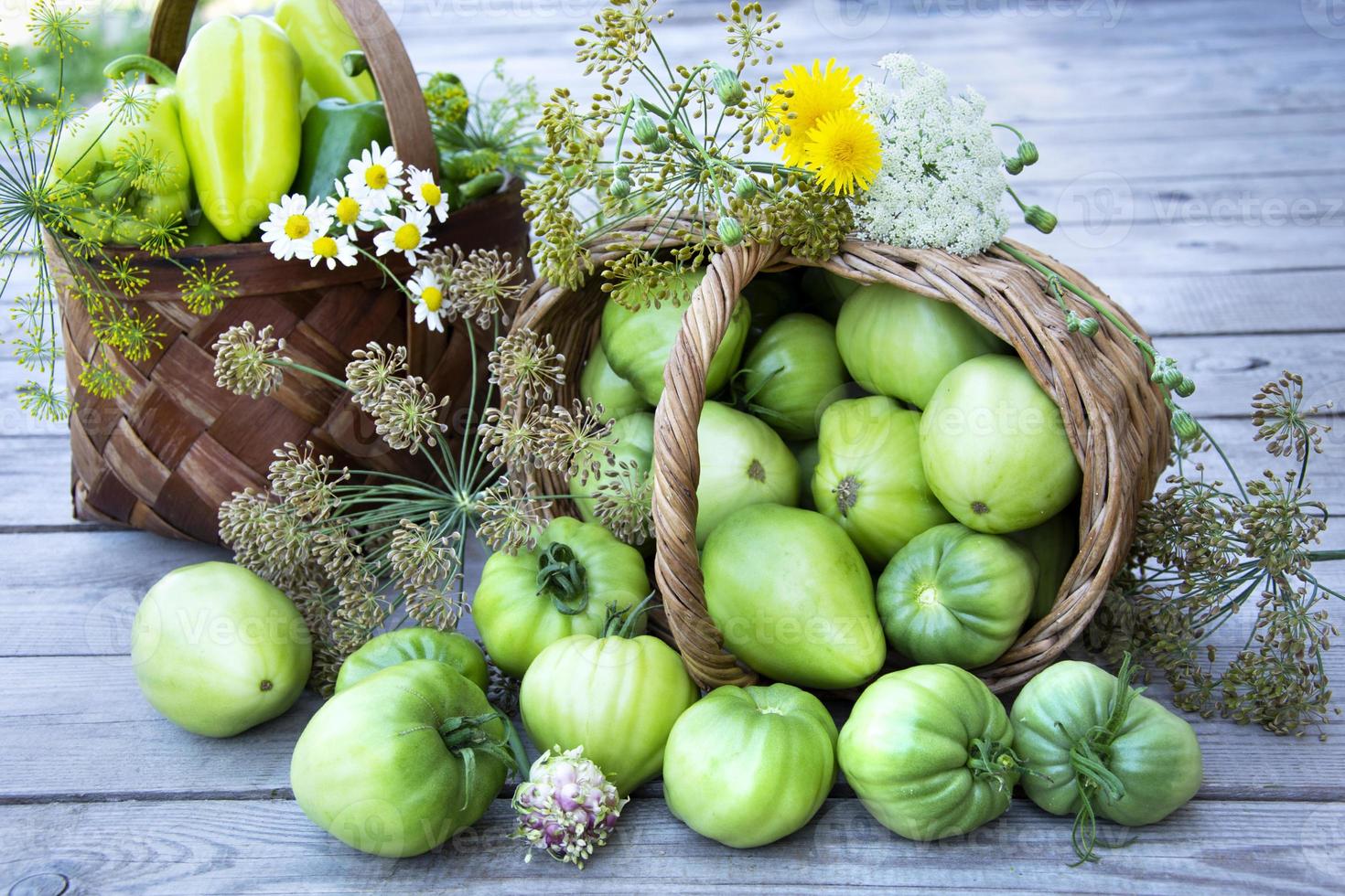 Vegetables in a basket and a bouquet of wildflowers photo