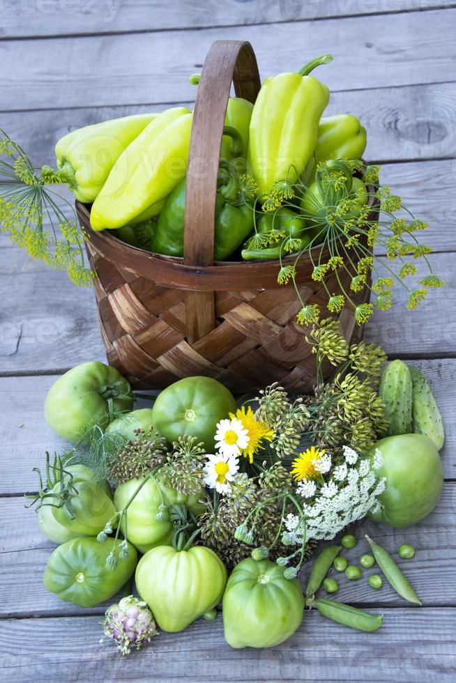 Vegetables in a basket on a wooden background photo