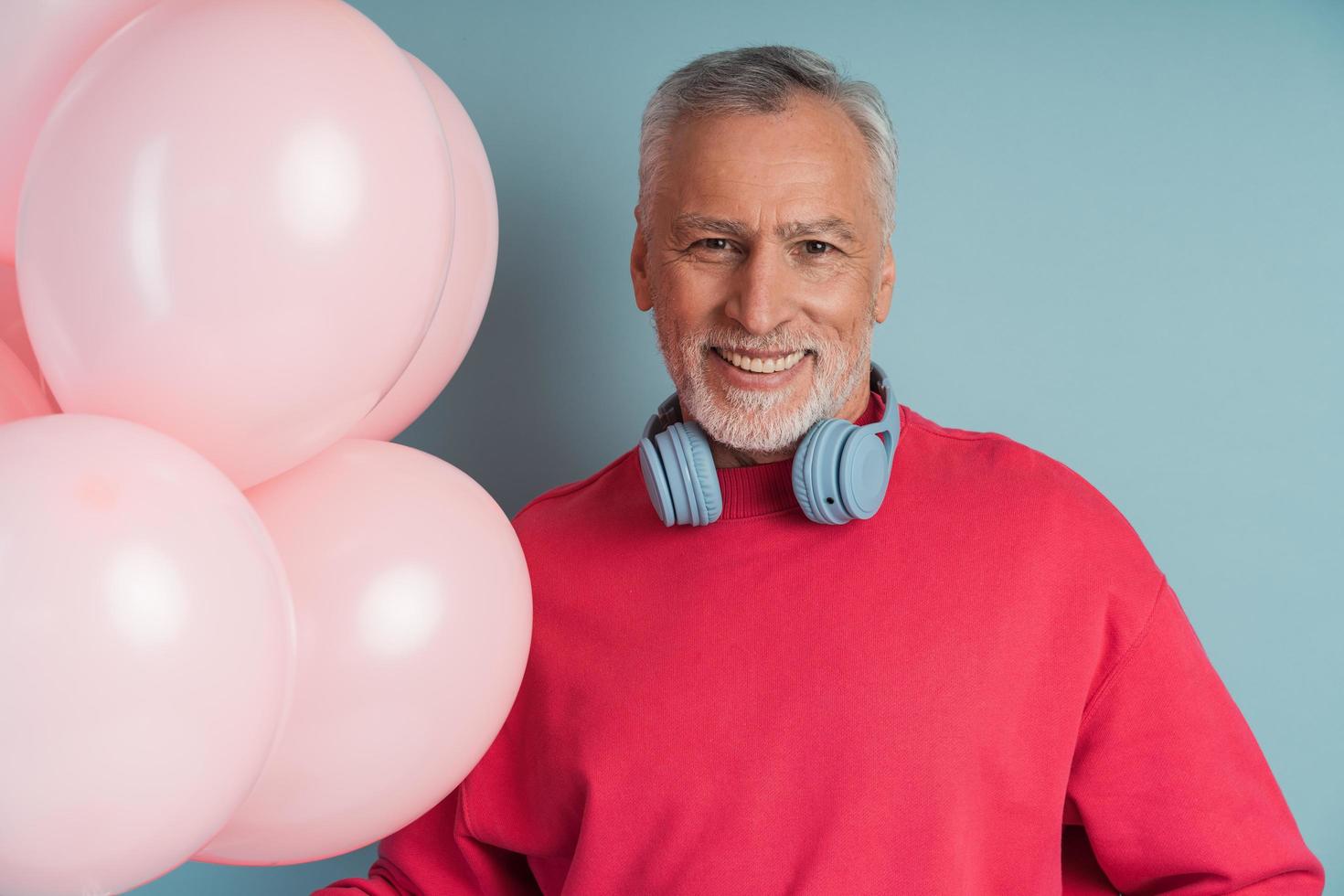 Hombre guapo y sonriente con cabello gris usa audífonos foto