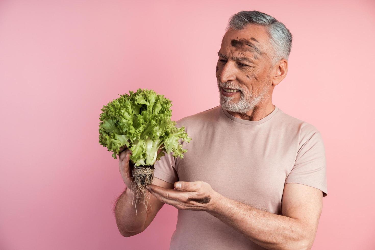 Handsome man is holding a handful of lettuce leaves photo