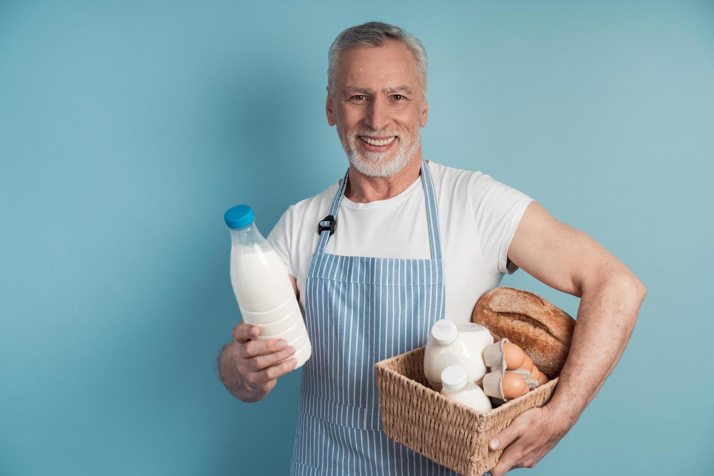 Senior, lindo hombre sosteniendo una canasta de comestibles foto