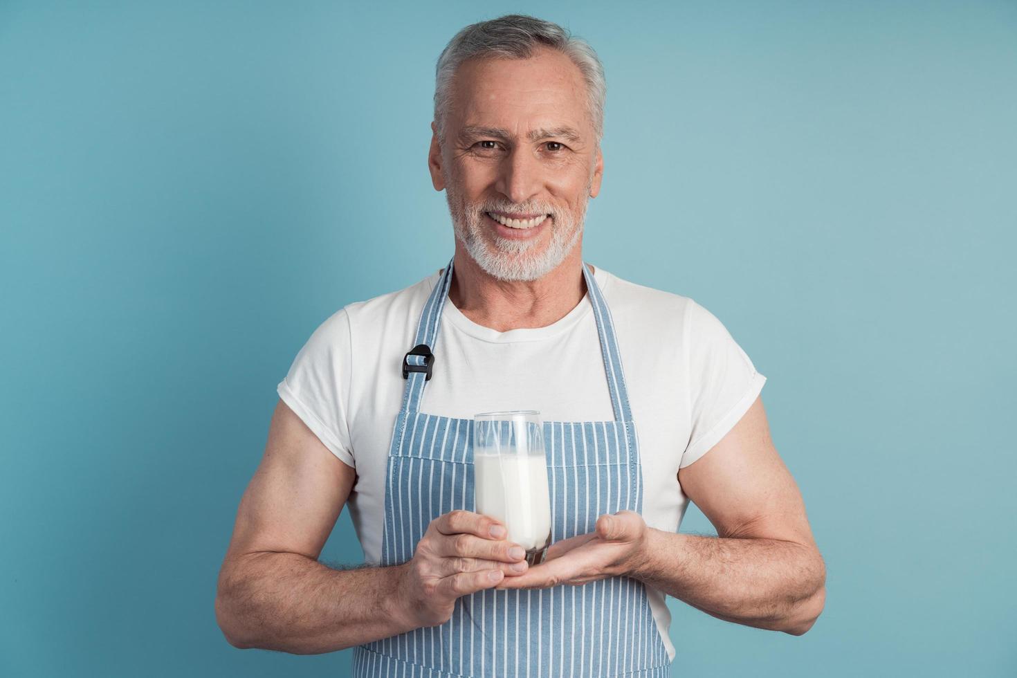 hombre sonriente sosteniendo un vaso de leche foto