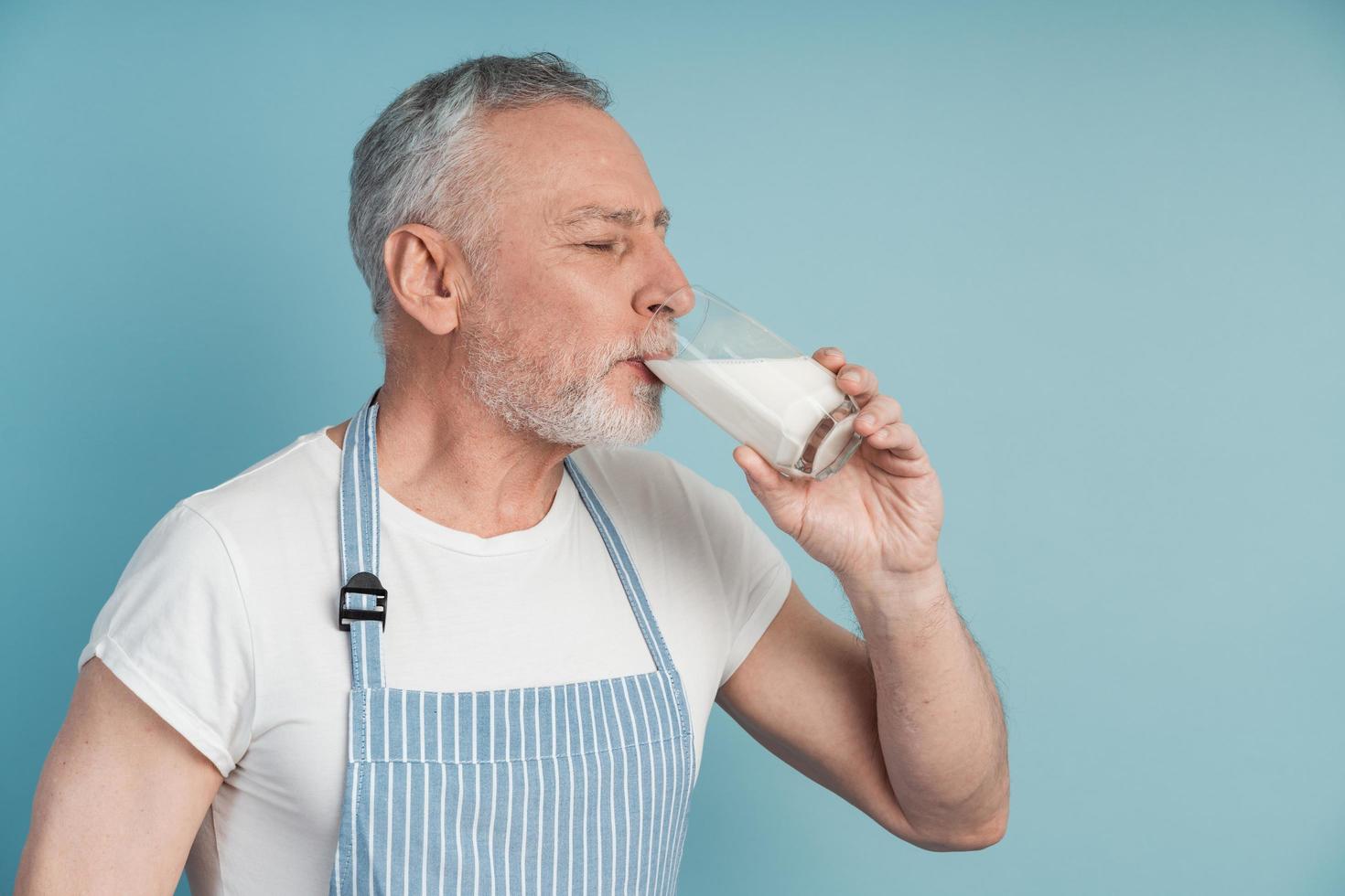 Side view, senior man drinking milk, closing his eyes photo