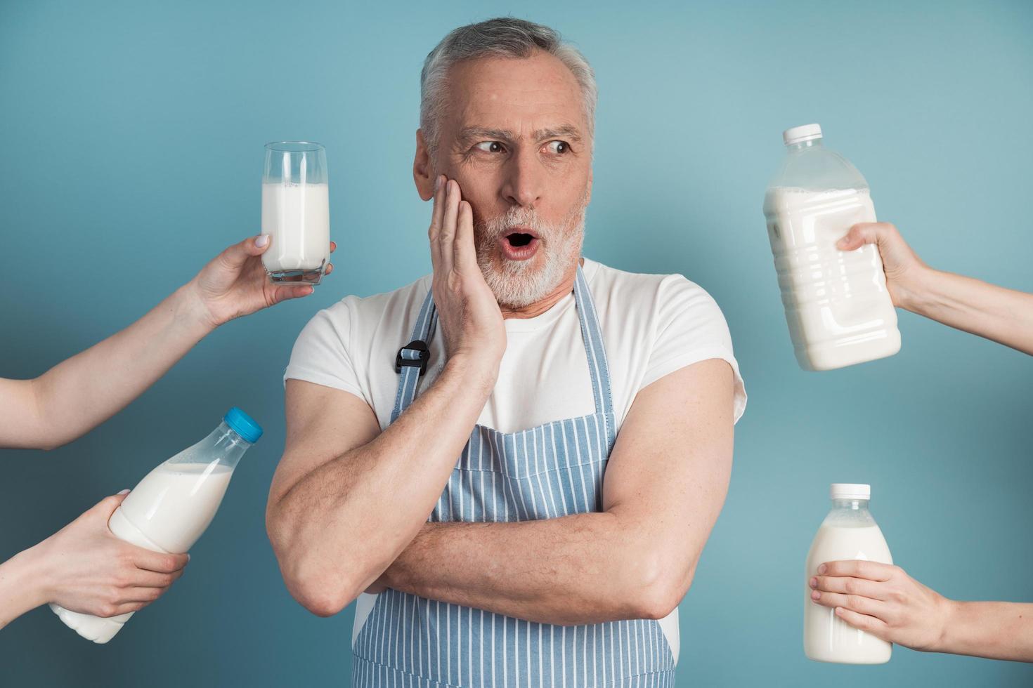 Surprised man touches his face with his hands, he wears an apron photo