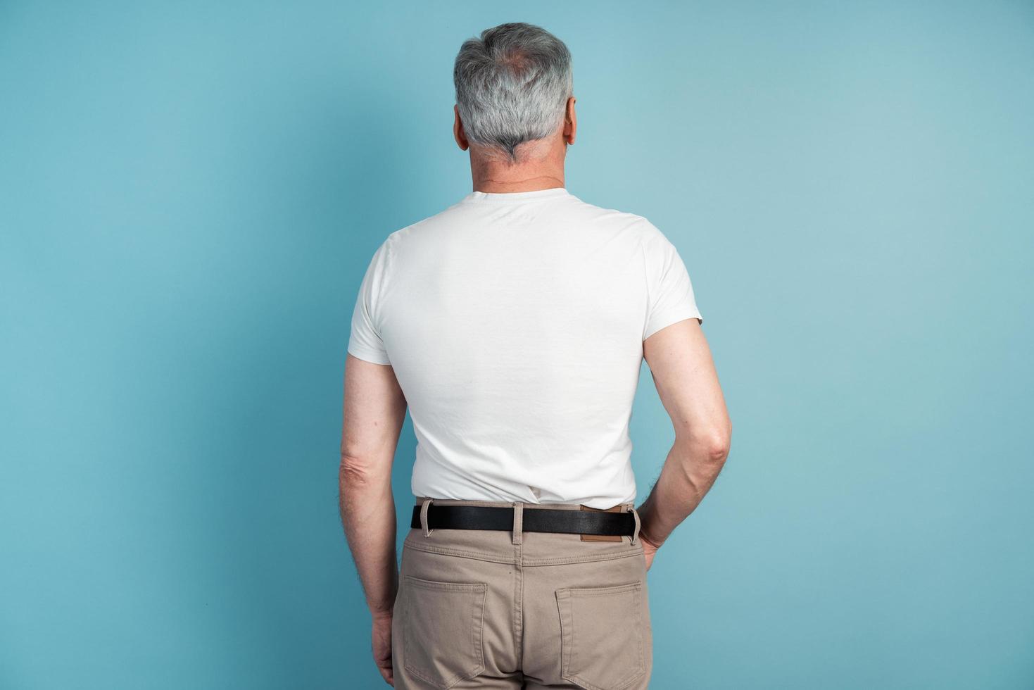 Rear view, a man in a white T-shirt with his back to the camera photo