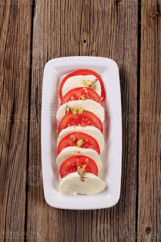 Slices of fresh tomato and mozzarella cheese photo