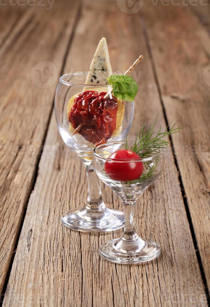 Dried tomato and slice of blue cheese in wine glass photo